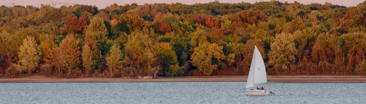 sailboat on a lake with fall leaves